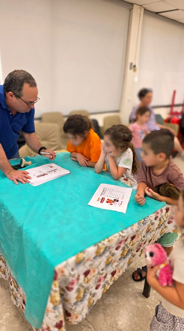 ד״ר תומר חותם על תעודת רופא צעיר לילד